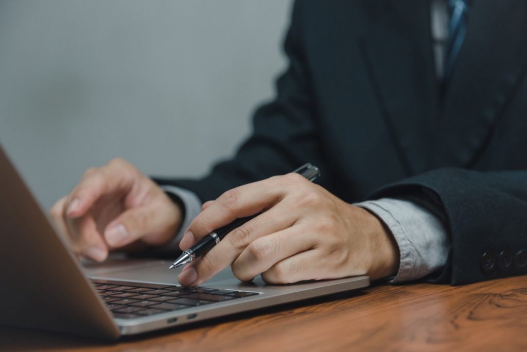  man working and typing on laptop computer keyboard