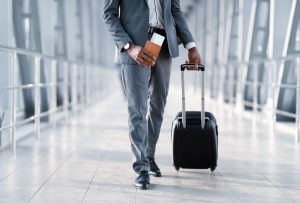man Moving To Departure Gate holding luggage and plane ticket