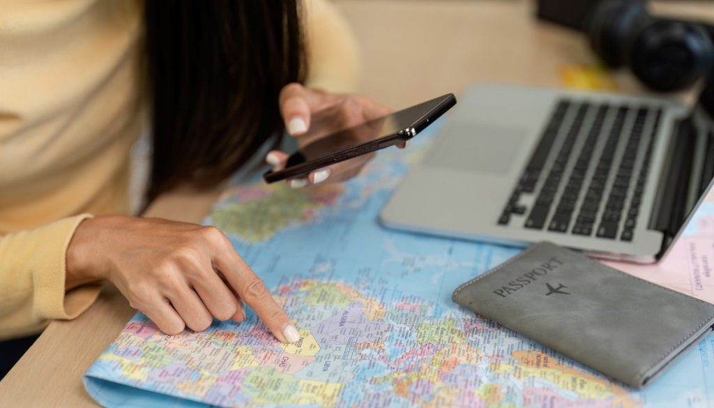 woman holding smartphone while checking a map