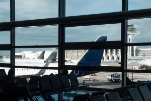 Airport terminal interior with large windows showcasing aircraft on tarmac