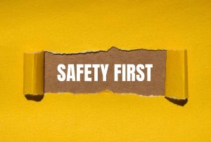 Safety first message written on ripped torn yellow paper