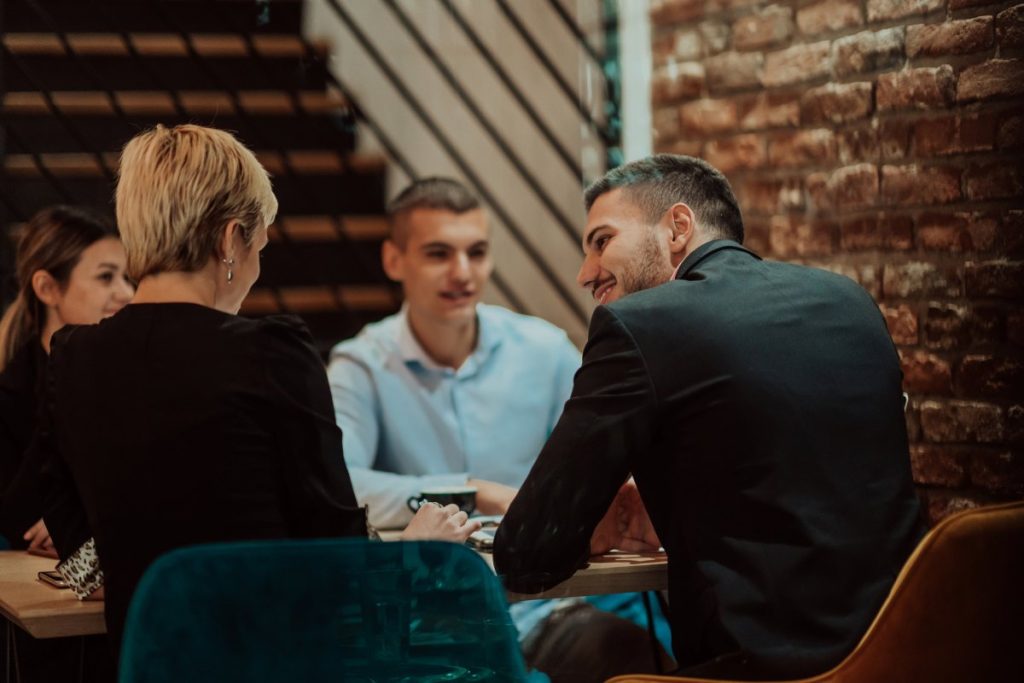 businesspeople smiling cheerfully during a meeting in a coffee shop