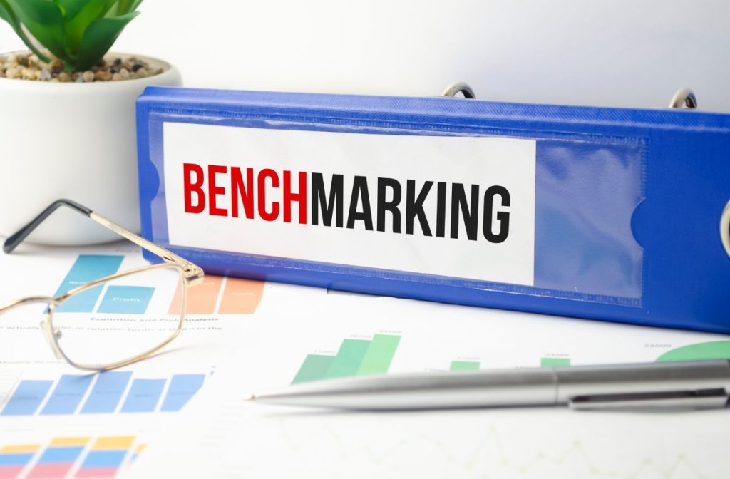 Word Benchmarking on blue file folder on charts