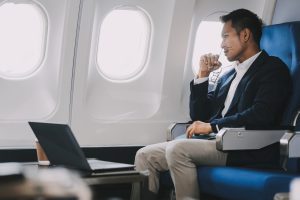 Business Man Having Headache Pain or Frustration Problem in Interior of an Airplane