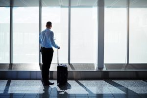 Vision, travel and businessman at airport window for international journey, thinking and luggage