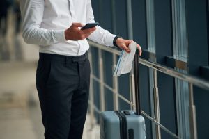 Close, up view of man with luggage and in formal clothes, conception of airport travel