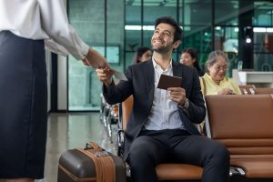 Businessman passenger is showing boarding pass to the airline ground crew at departure gate into the airplane for final inspection before boarding to plane